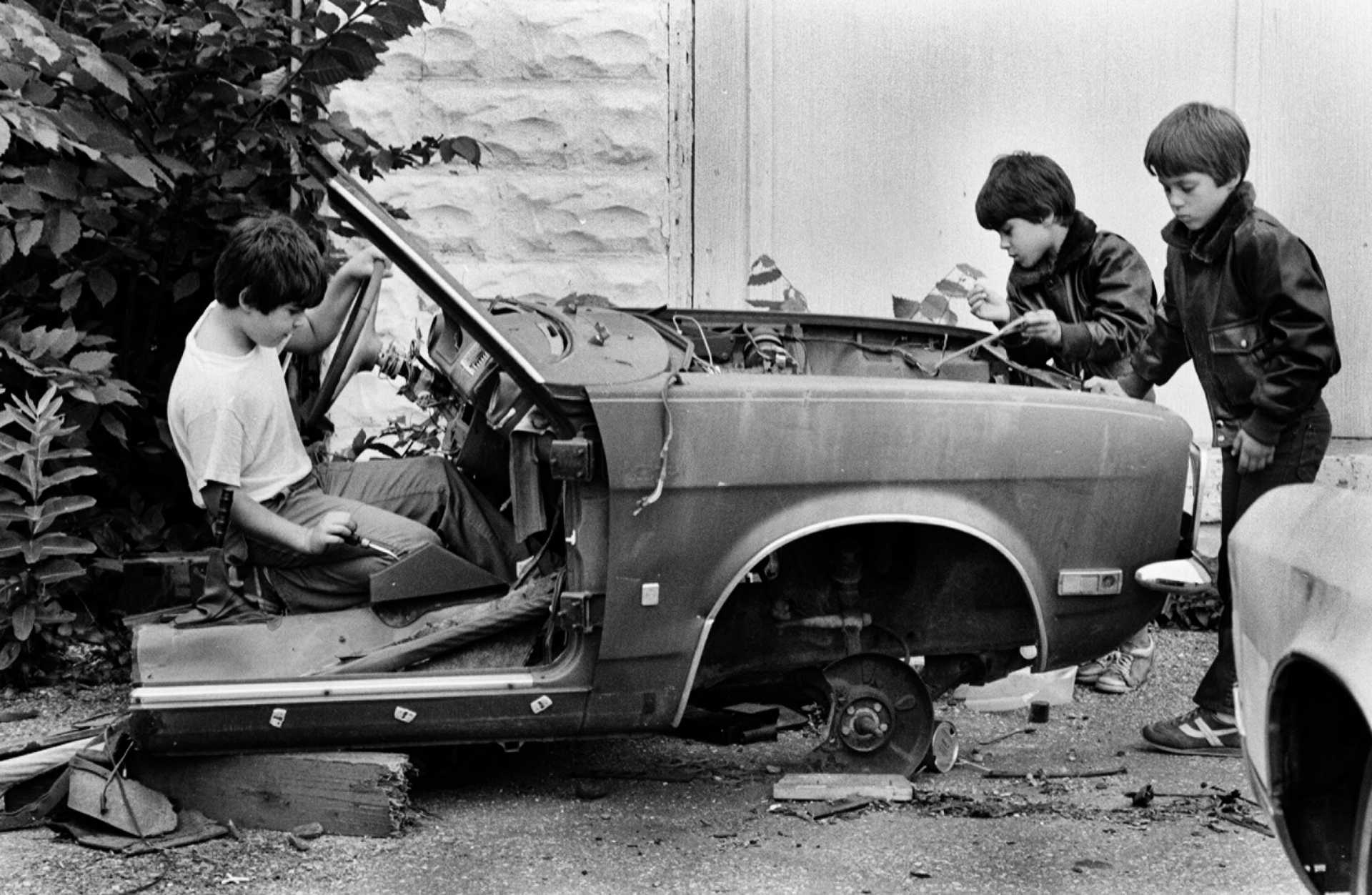 A junked car is a treasure find to boys on Main Street in Danbury. 1979