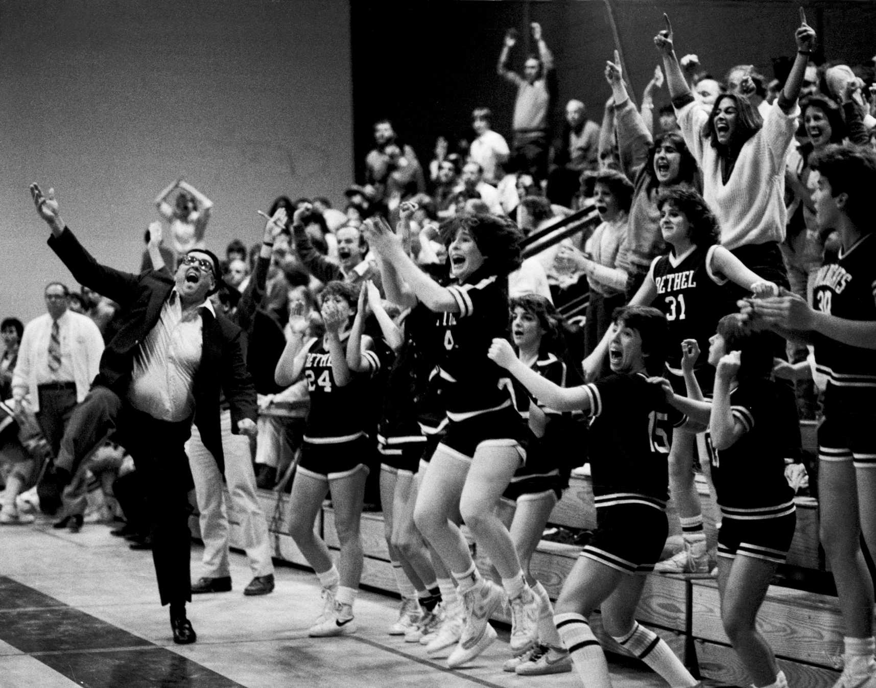 Coach, team and fans cheer a basketball championship win for the Bethel High School’s girls team. 1985