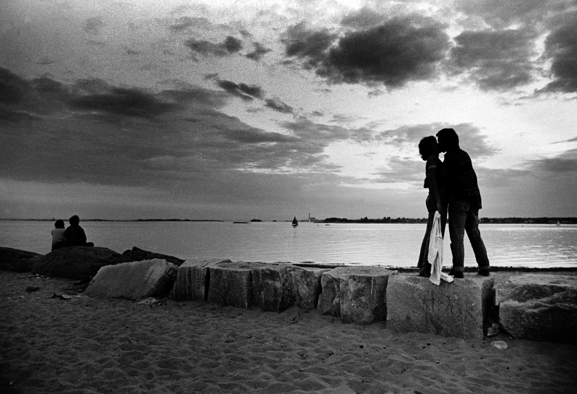Lovers silhouetted on Compo Beach in Westport, Conn. 1970s