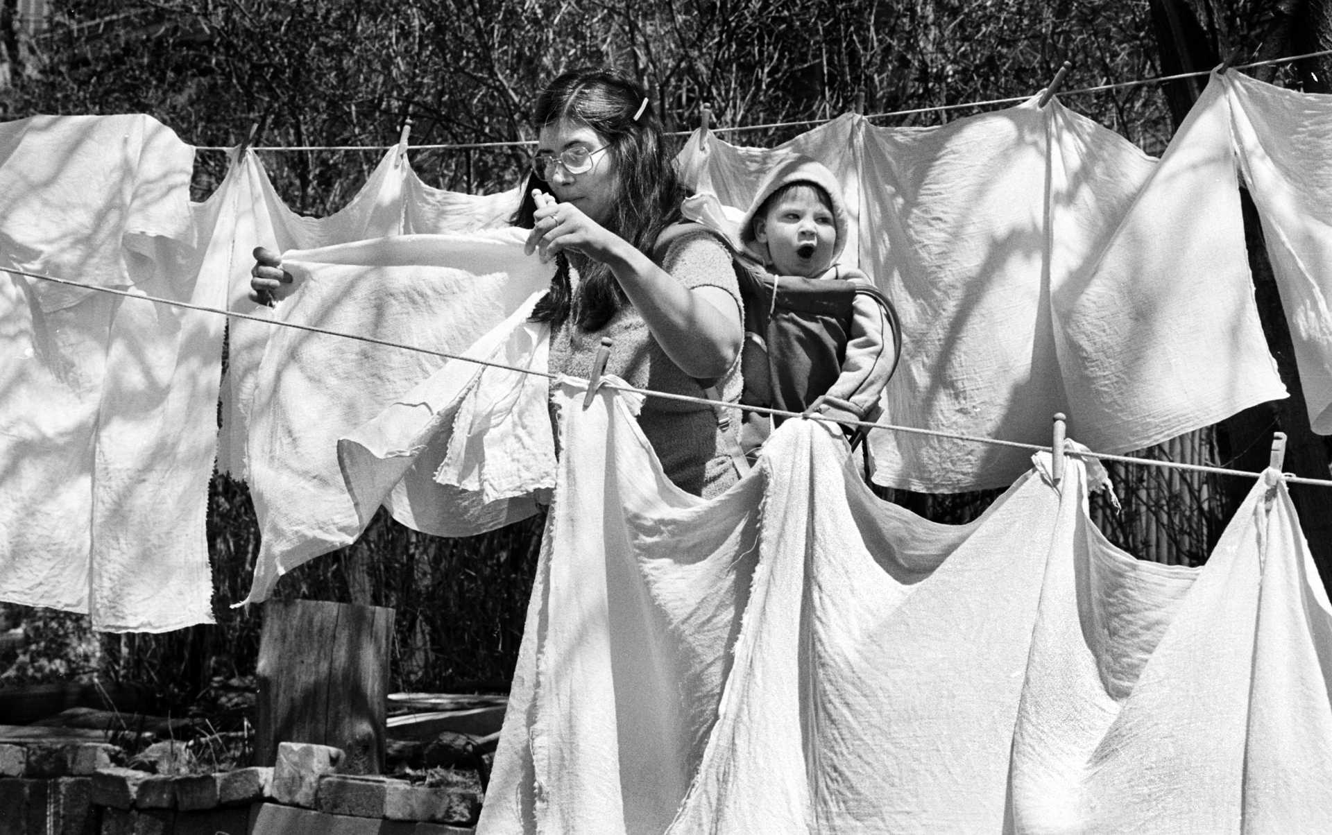 A young mother hangs diapers out to dry. 1980