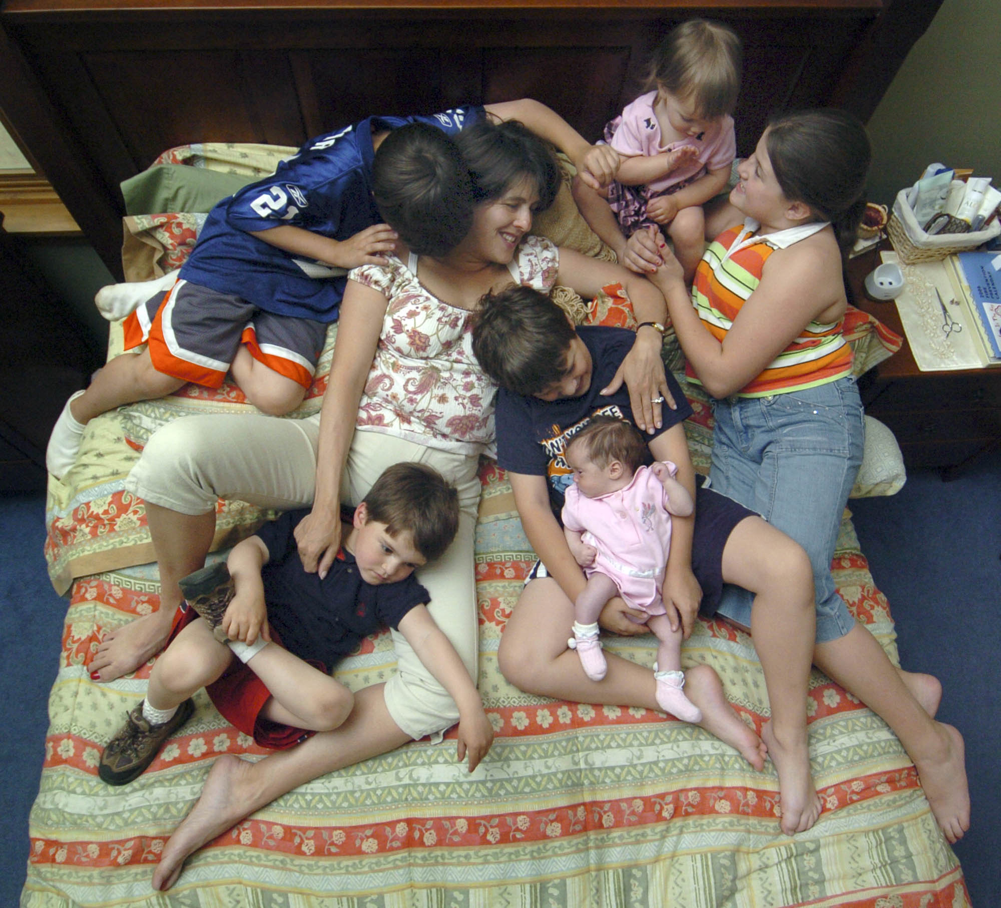 Lenore Wichman snuggles with her six children in one of their favorite spots, their parent's bed. This is part Mother's Day story.