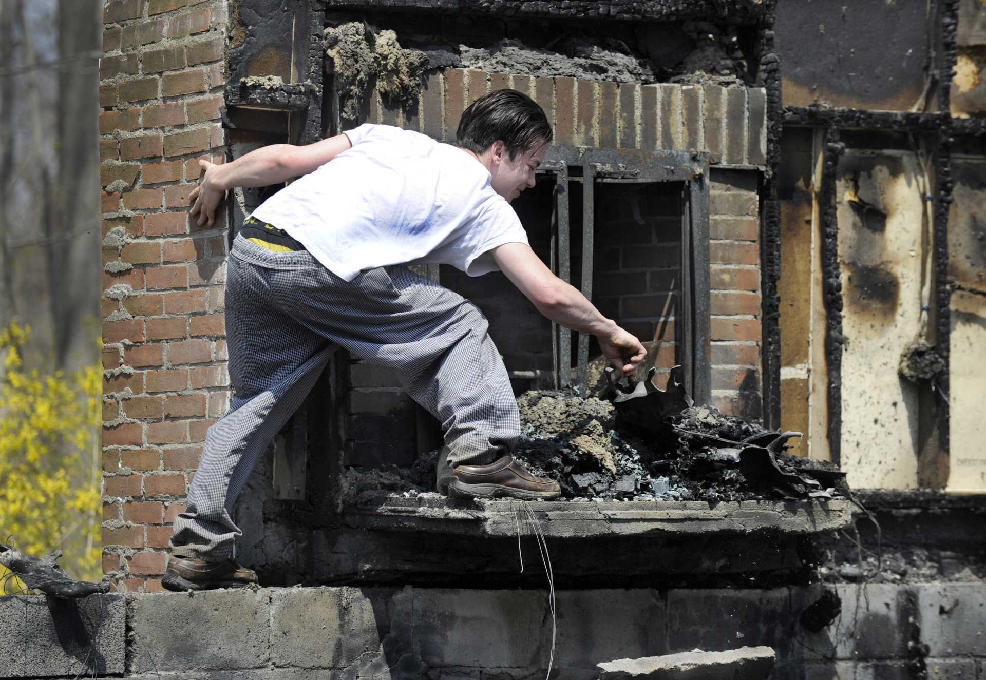 A young man walks through the rubble that is left after an early morning fire destroyed his home.
