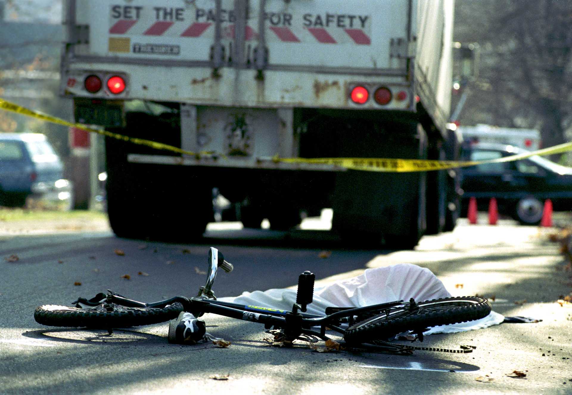 The body of an 11-year-old boy lies next to his bicycle after fatally sliding into a truck. 
