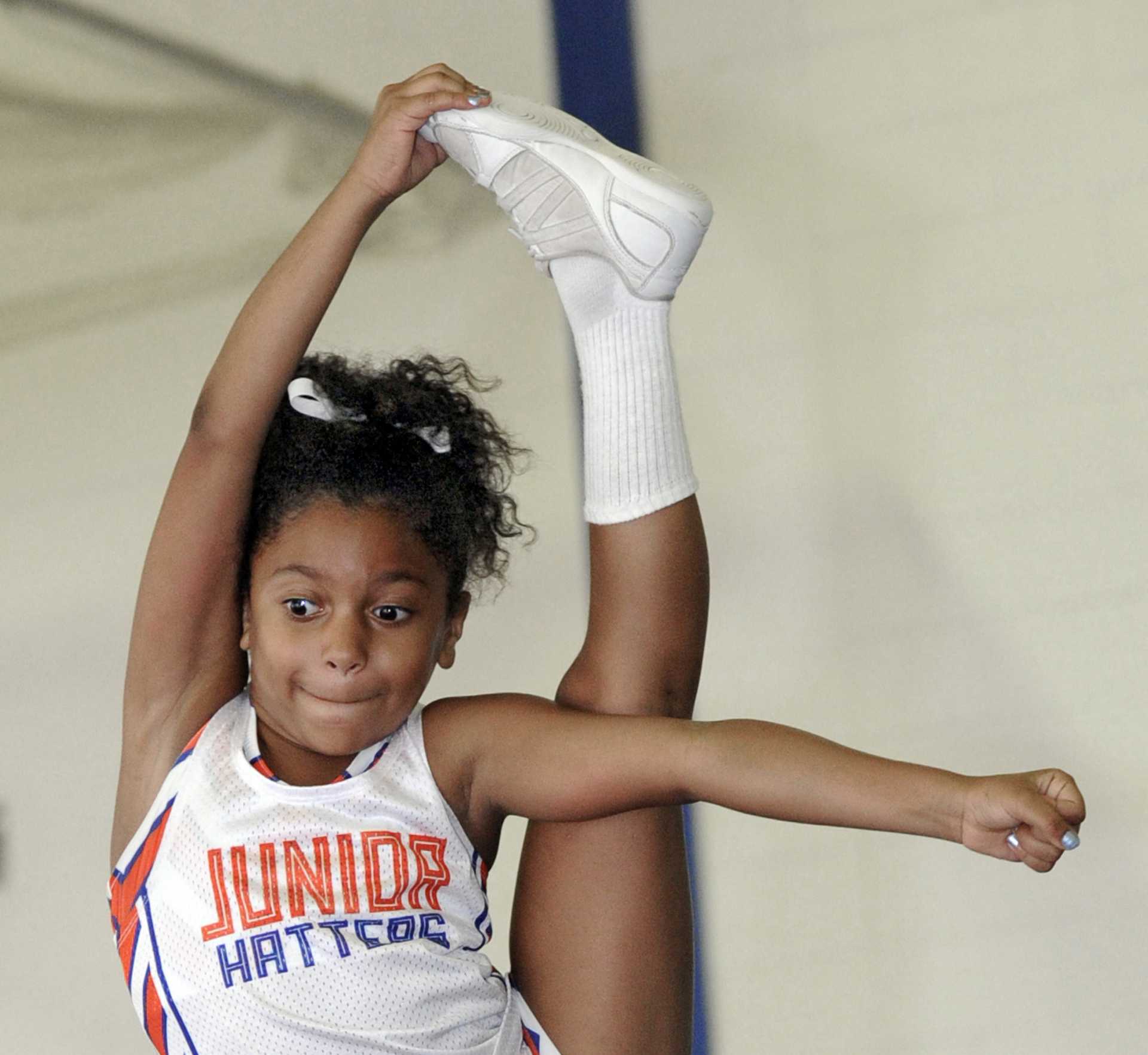 Displaying extreme flexibility, Ella Brown, 8, of Danbury, a flier for the Danbury Junior Hatters cheerleaders, practices a ''needle''.