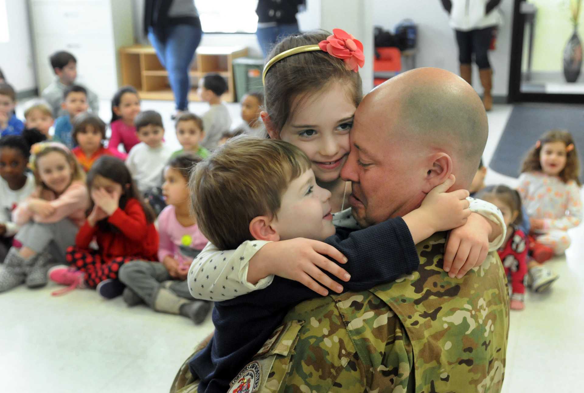 After an absence of six months, children hug their soldier father when he surprised them with a visit to their school. Thomas Geanuracos, 41, a Danbury police officer and Air National Guardsman had been stationed in Iraq.