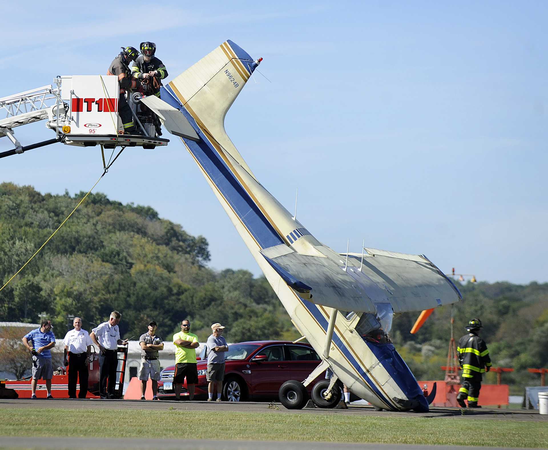 Firefighters rescue a plane after the pilot experienced a rough landing at Danbury Airport. 